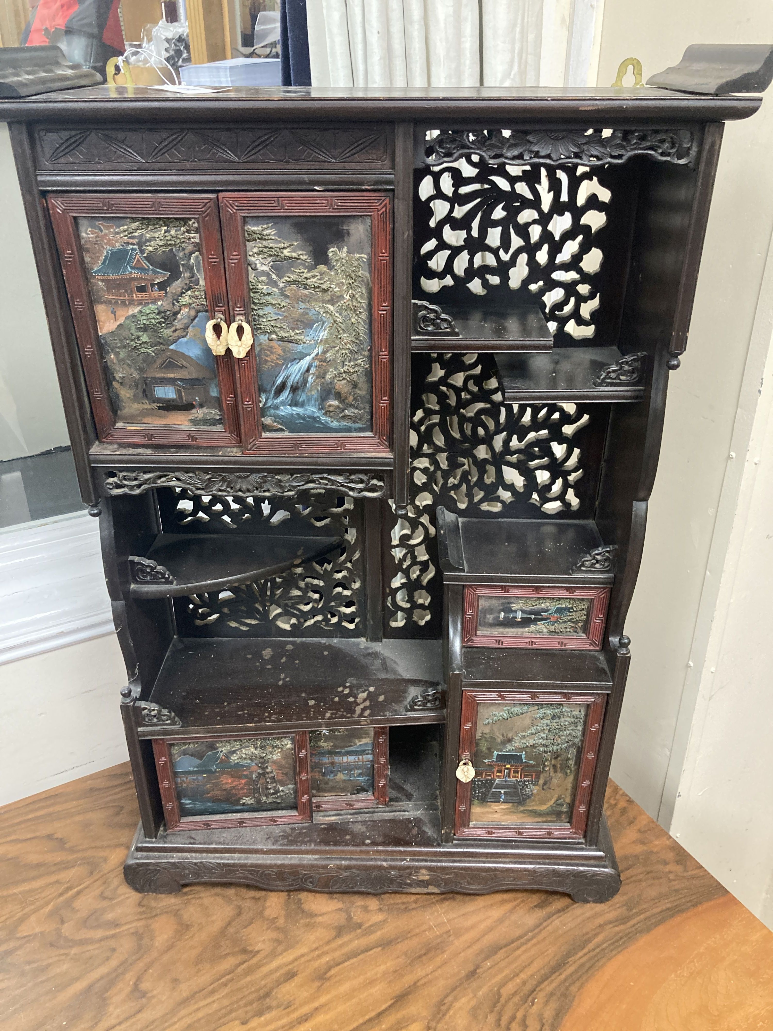 A 20th century Chinese carved cabinet with painted hinged cupboard doors, 79cm height, width 52cm, depth 18cm